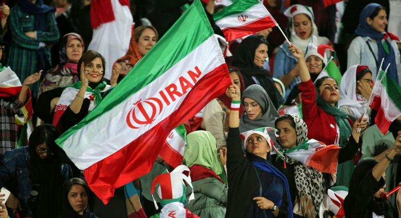 Iranian women cheer ahead of the World Cup Qatar 2022 Group C qualification football match between Iran and Cambodia at the Azadi stadium in the capital Tehran on October 10, 2019 Creator: ATTA KENARE