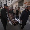 Palestinci nose telo osobe poginule u izraelskim vazdušnim napadima u petak, usmerenim na Iza al Dina al Hadada, vođu Hamasa