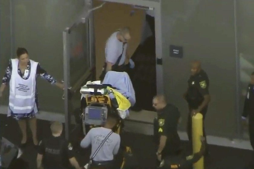 Police escort a suspect into the Broward Jail after checking him at the hospital following a shootin