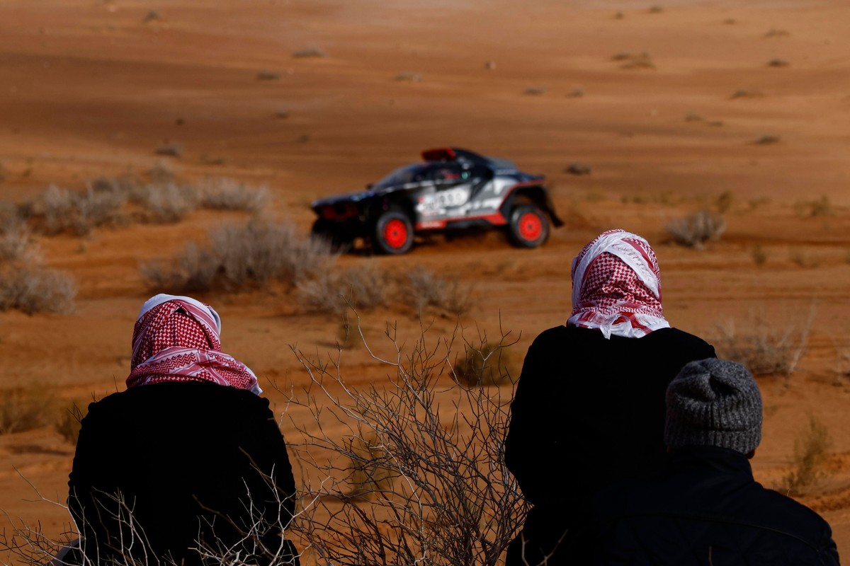 Kibice na trasie etapu 1B tegorocznego Rajdu Dakar; w tle Carlos Sainz za kierownicą Audi