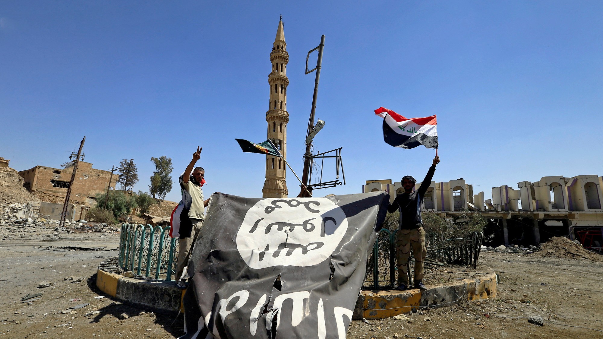 Členovia šiitských ľudových mobilizačných síl (PMF) držia vlajku Islamského štátu