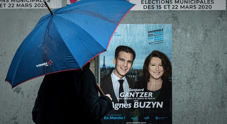 A man passes electoral poster ahead of the first round of the mayoral elections in Paris, as polls show Socialist incumbent Anne Hidalgo leading the race