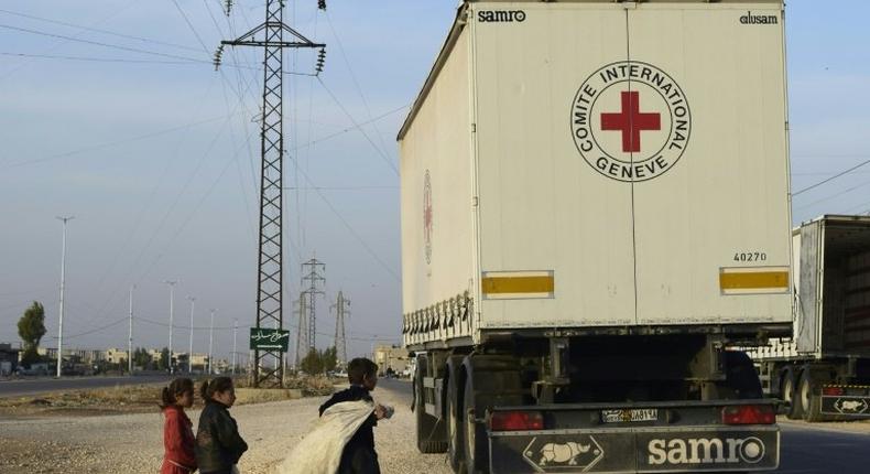 Syrian children gather around a lorry after an aid convoy of the International Committee of the Red Cross (ICRC) and the Syrian Arab Red Crescent entered the rebel-held town of Rastan, in central Homs province, on November 22, 2016