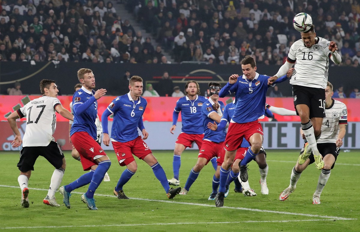 Niemiec Lukas Nmecha (P) i Liechtensteińczyk Rafael Grunenfelder (2-R) podczas meczu el. MŚ 2022