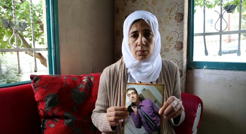 Manal al-Saayed, the mother of Israeli citizen Hisham al-Sayed, holds a picture of her son who is believed to have been held by Hamas since April 2015