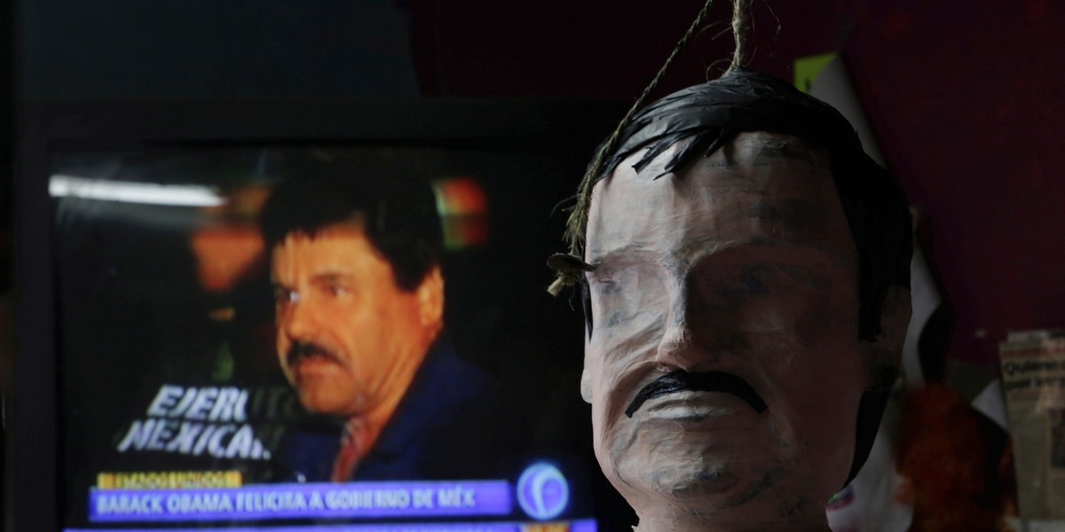 A piñata in progress depicting the drug lord Joaquin "El Chapo" Guzman is seen in front of a television showing a news bulletin of him, at a workshop in Reynosa, in Tamaulipas state, Mexico, January 13, 2016.