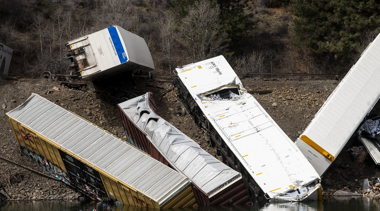 Megrongálódott vasúti kocsikat közelítenek meg csónakkal helybeliek a Clark Fork folyó partján, a Montana állambeli St. Regis város  miután a tehervonat mintegy két tucat kocsija kisiklott egy alagútnál / Fotó: MTI / AP / Ben Allan Smith