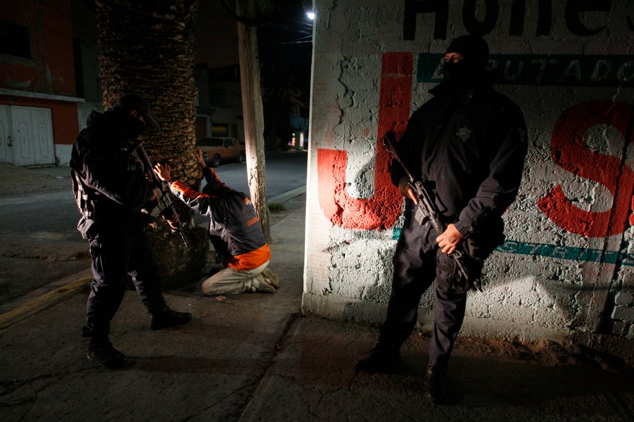 Federal police search men for drugs and weapons during an antinarcotics operation in Ecatepec, Mexico, November 13, 2009.