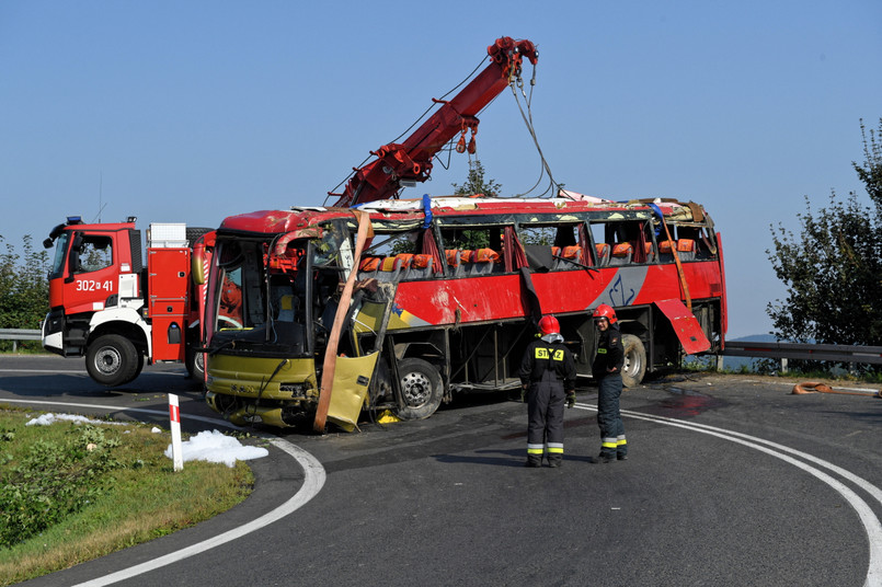 Strażacy usuwają wrak ukraińskiego autokaru wycieczkowego na drodze krajowej nr 28 w Leszczawie.