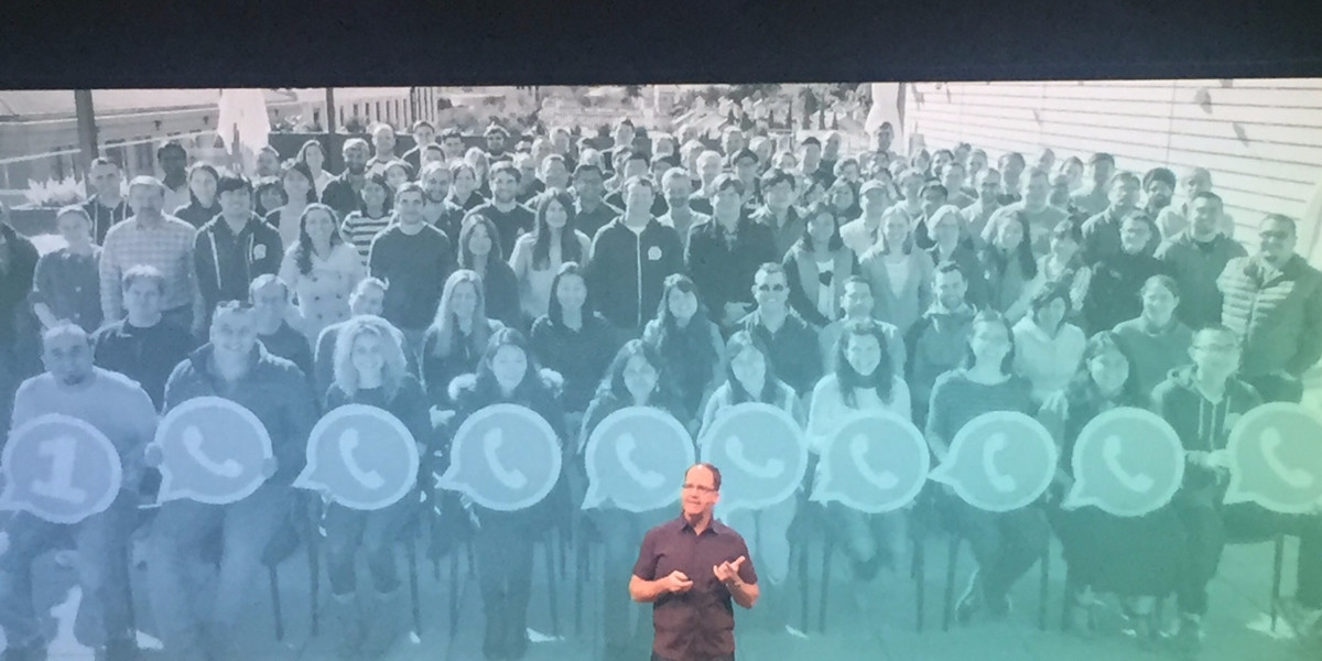 WhatsApp software engineer Rick Reed speaks at Facebook's F8 2016 conference. Behind him is a picture of all 57 engineers with WhatsApp.