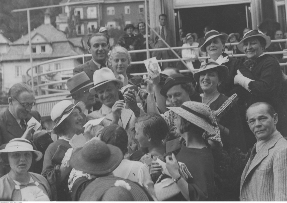 Jan Kiepura rozdaje autografy swym wielbicielom zebranym przed hotelem Patria. Z prawej widoczny ojciec artysty Franciszek Kiepura (1935 r.)