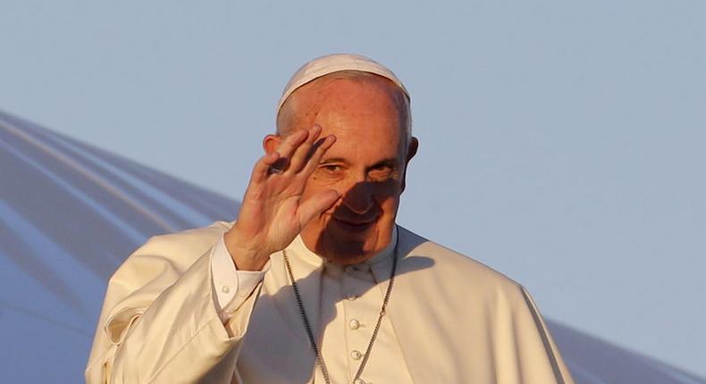 Pope Francis waves as he boards a plane at Fiumicino Airport in Rome November 25, 2015.   REUTERS/Giampiero Sposito