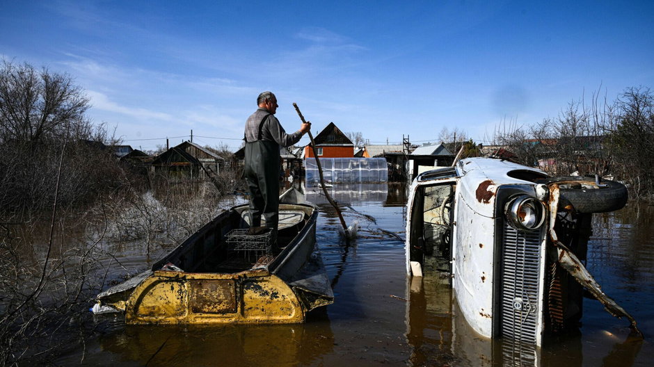 Mężczyzna nawiguje na tratwie przez zalane ulice Orska, 11 kwietnia 2024 r.