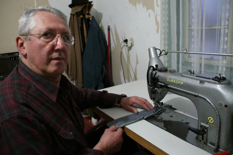 Mališa Zindović u svom domu za šivaćom mašinom i sa iglom i koncem ručno šije