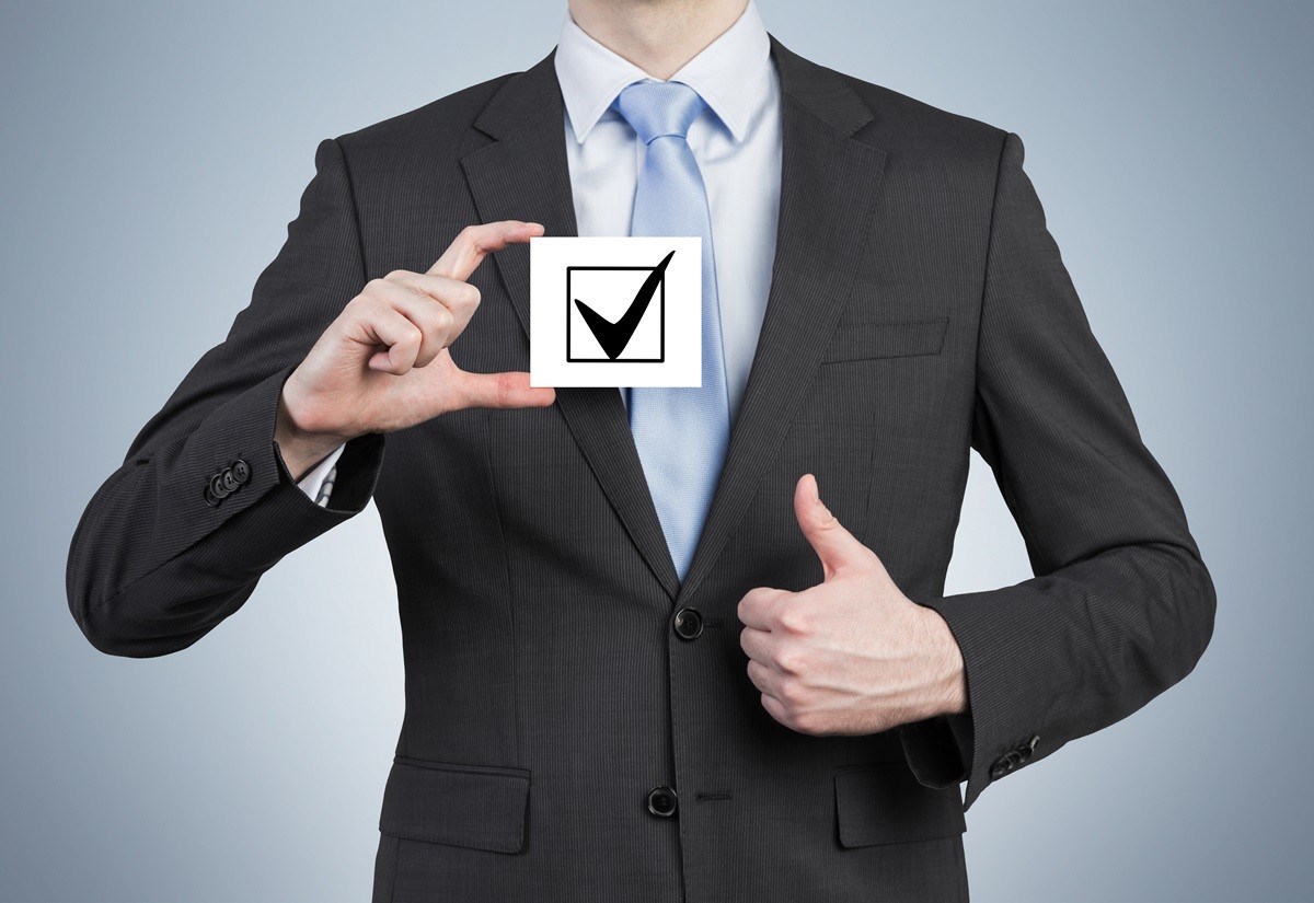 Mężczyzna w garniturze ze znakiem checklisty