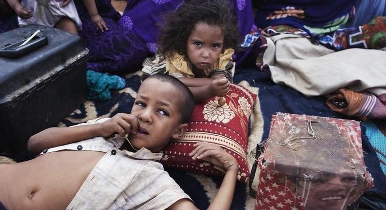 Elah, 7, (L) and Tahye Iselkou, 5, lie next to a box draped with a picture of U.S. President Barack Obama on the floor of their shelter at Mbera refugee camp in southern Mauritania, May 24, 2012. REUTERS/Joe Penney