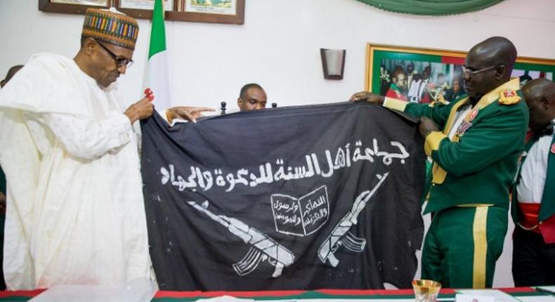 Army presents captured Boko Haram flag to President Muhammadu Buhari (NAN)