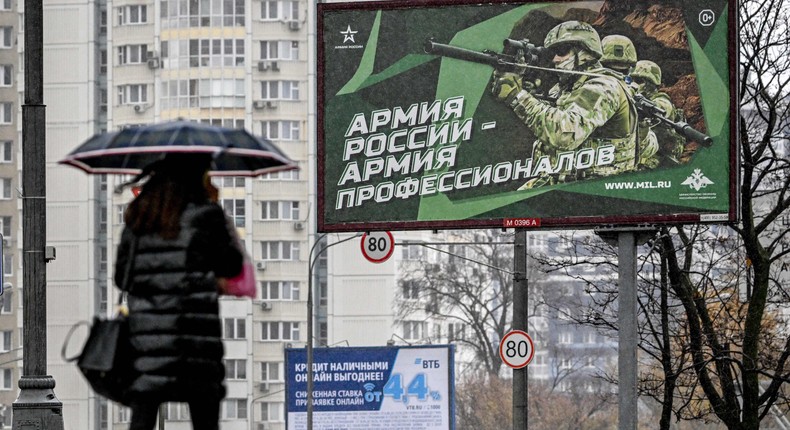 A pedestrian walks past a poster displaying Russian soldiers with a slogan reading 'Army of Russia - Army of professionals' decorating a street in Moscow on October 24, 2022.YURI KADOBNOV/AFP via Getty Images