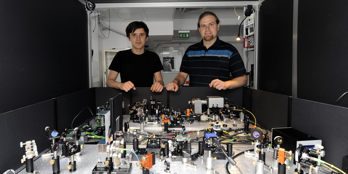 Dr Radosław Chrapkiewicz (po prawej) i doktorant Michał Jachura przy aparaturze do rejestrowania hologramów pojedynczych fotonów