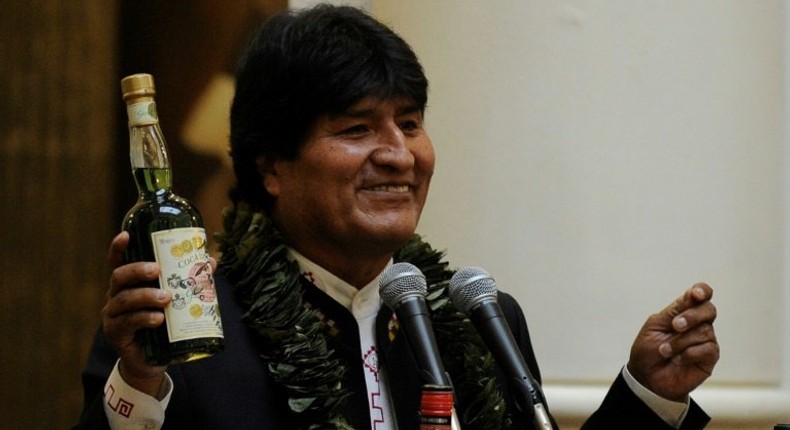 Bolivian President Evo Morales shows a bottle containing a coca-based drink during the ceremony to promulgate a government bill increasing the legal areas of cultivation of coca, at the Quemado presidential palace in La Paz, on March 8, 2017