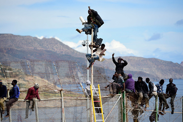 Flyktninger prøver å bryte gjennom gjerdet og komme seg til Melilla