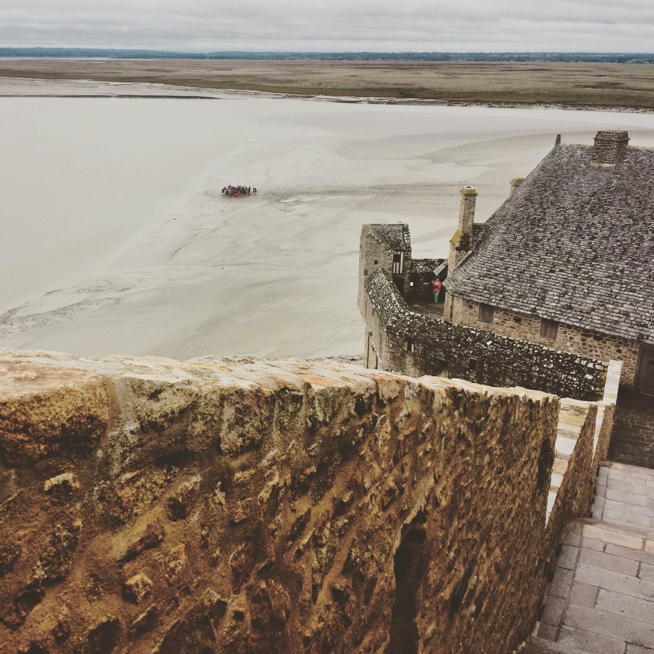 Wyrastająca z morza wyspa Mont St-Michel widoczna jest już z daleka, a z lądem połączona jest wąską groblą.