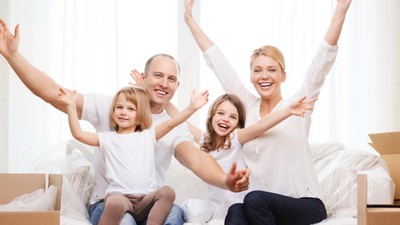 smiling parents and two little girls at new home