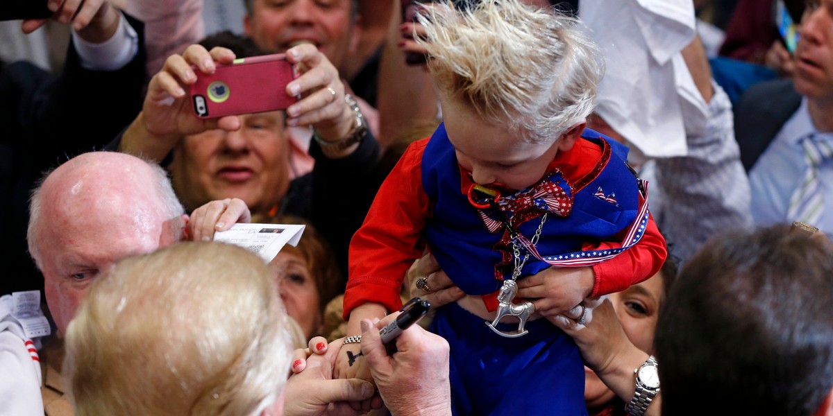 Donald Trump signs the hand Curtis Ray Jeffrey II, whose hair was stylized to resemble Trump's.