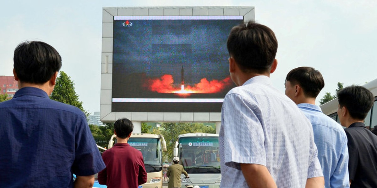 North Koreans watch a news report showing the Hwasong-12 intermediate-range ballistic missile launch, in Pyongyang, in this photo taken by Kyodo, August 30, 2017.