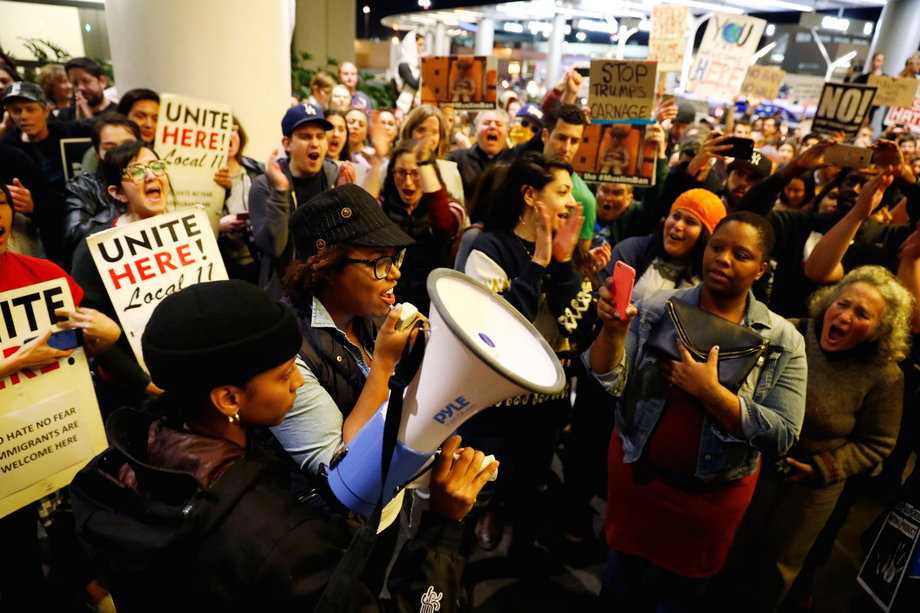 A protester announces a court decision blocking deportations as people protest against U.S. President Donald Trump's travel ban on Muslim majority countries at the International terminal at Los Angeles International Airport (LAX) in Los Angeles, California, U.S., January 28, 2017.