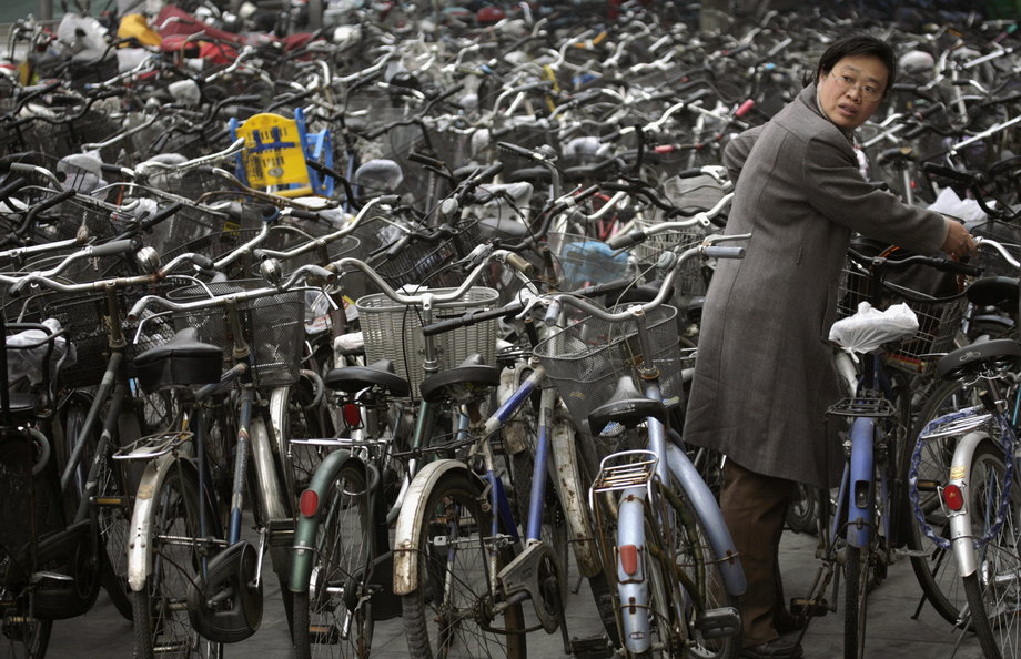Kobieta zabiera swój rower z parkingu rowerowego pod stacją metra w Pekinie.