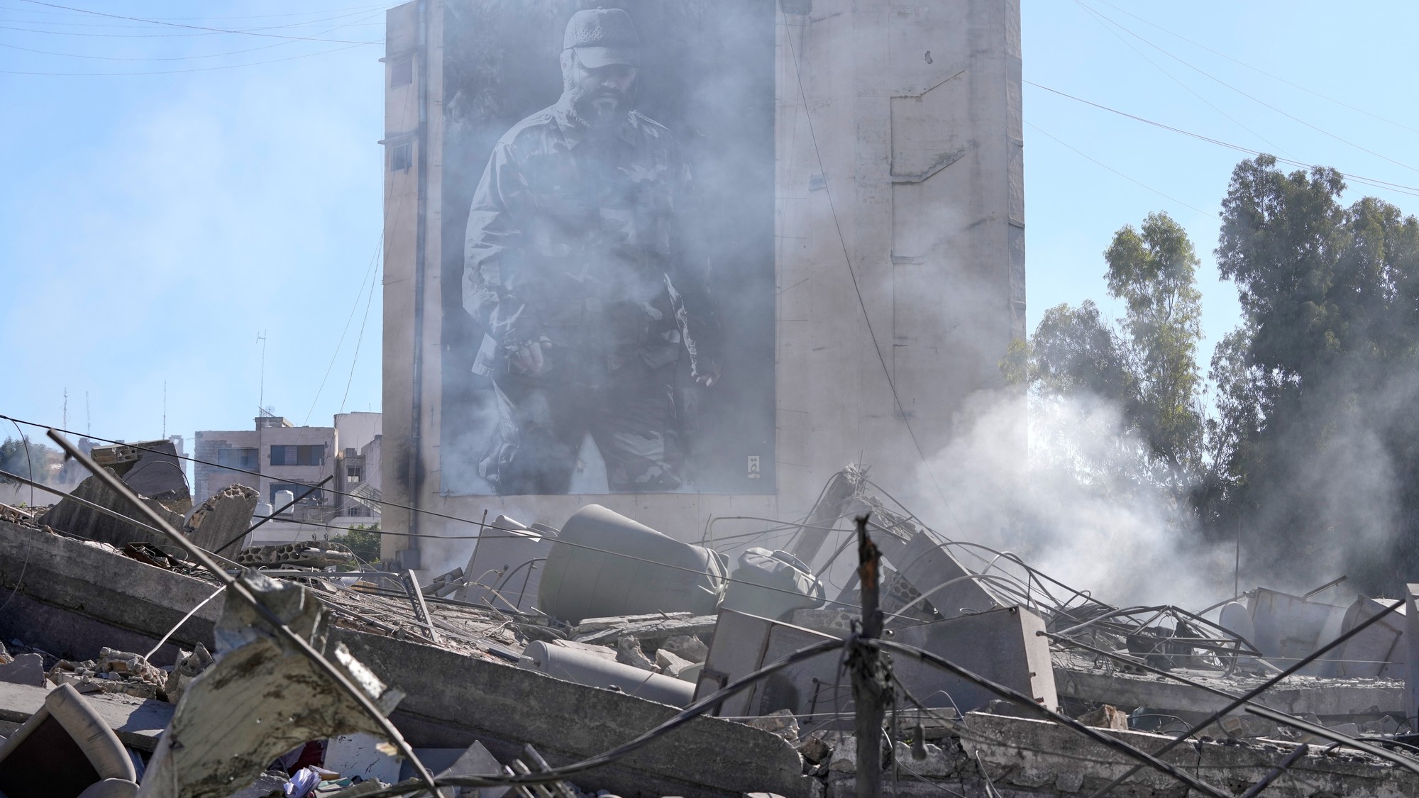 Plagát zosnulého vojenského veliteľa Hizballáhu Imáda Mughníju je vidieť za zničenou budovou, ktorú zasiahli izraelské nálety v meste Nabátíja na juhu Libanonu, vo štvrtok 5. marca 2026.