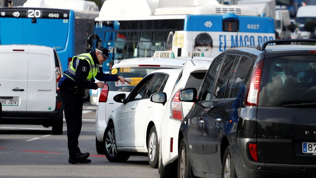 A police traffic officer speaks to motorists entering the center of Madrid