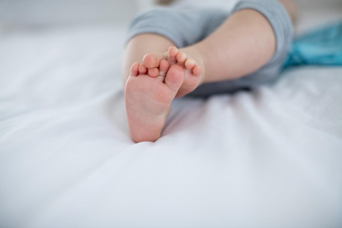 Детские ноги в кровати