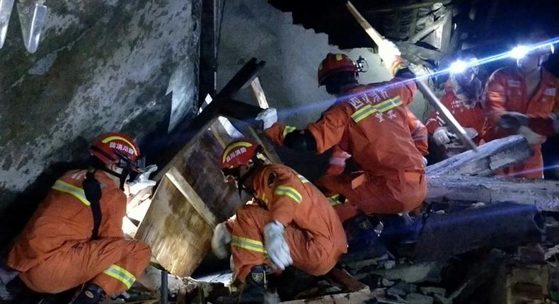 Rescuers search for earthquake survivors in the rubble of a building in Yibin, in China's Sichuan province