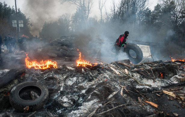 Prorysyjscy demonstranci na płonącej barykadzie w pobliżu Słowiańska. Fot. EPA/ROMAN PILIPEY