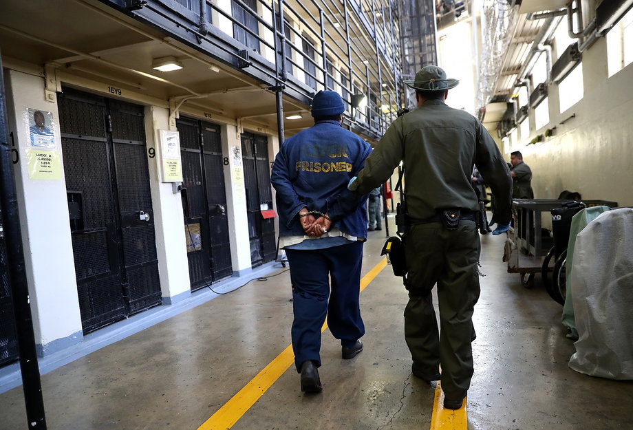 An inmate is escorted through San Quentin State Prison in California.