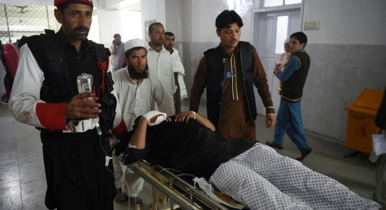Medics move an injured member of the security personnel at a hospital in Peshawar on February 15, 2017, after a suicide bombing on a government compound in Mohmand tribal agency in Pakistan's northwest