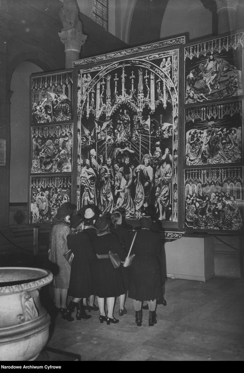 Grupa kobiet na wystawie prac Wita Stwosza (prawdopodobnie) w Berlinie ogląda ołtarz z Kościoła Mariackiego w Krakowie
