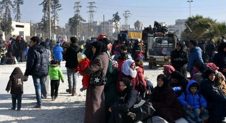 Syrian civilians wait a checkpoint manned by pro-government forces after leaving Aleppo's eastern neighbourhoods on December 10, 2016