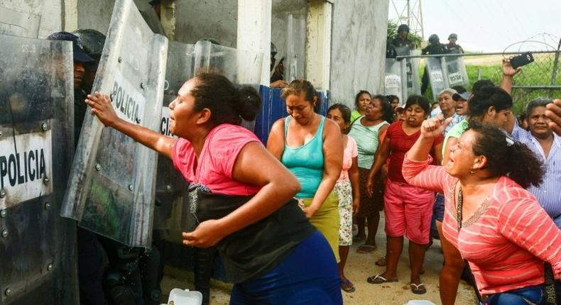 Relatives of inmates struggle with riot police outside Las Cruces prison in Acapulco, following a riot in the facility that left 28 dead and three wounded