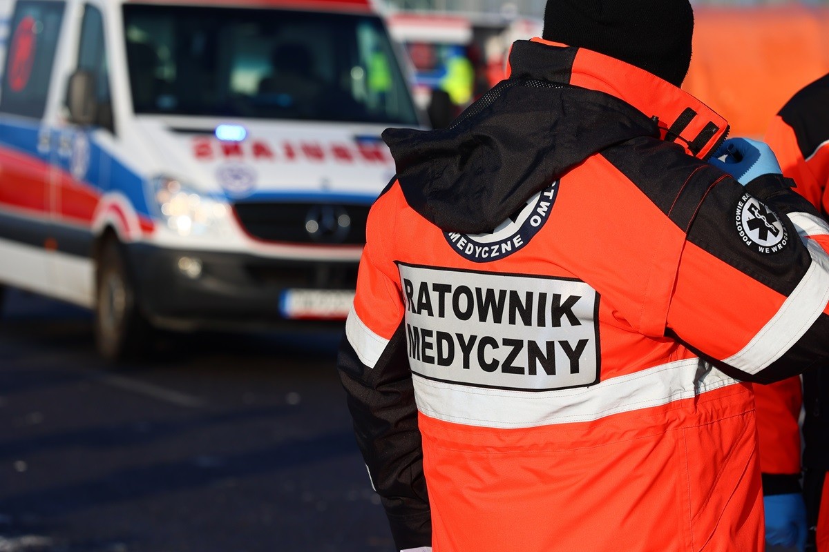 Ratownik medyczny, w tle karetka pogotowia