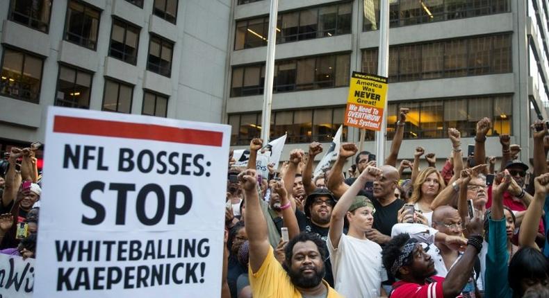 Activists raise their fists at a rally in support of NFL quarterback Colin Kaepernick outside the offices of the National Football League on Park Avenue, in New York City