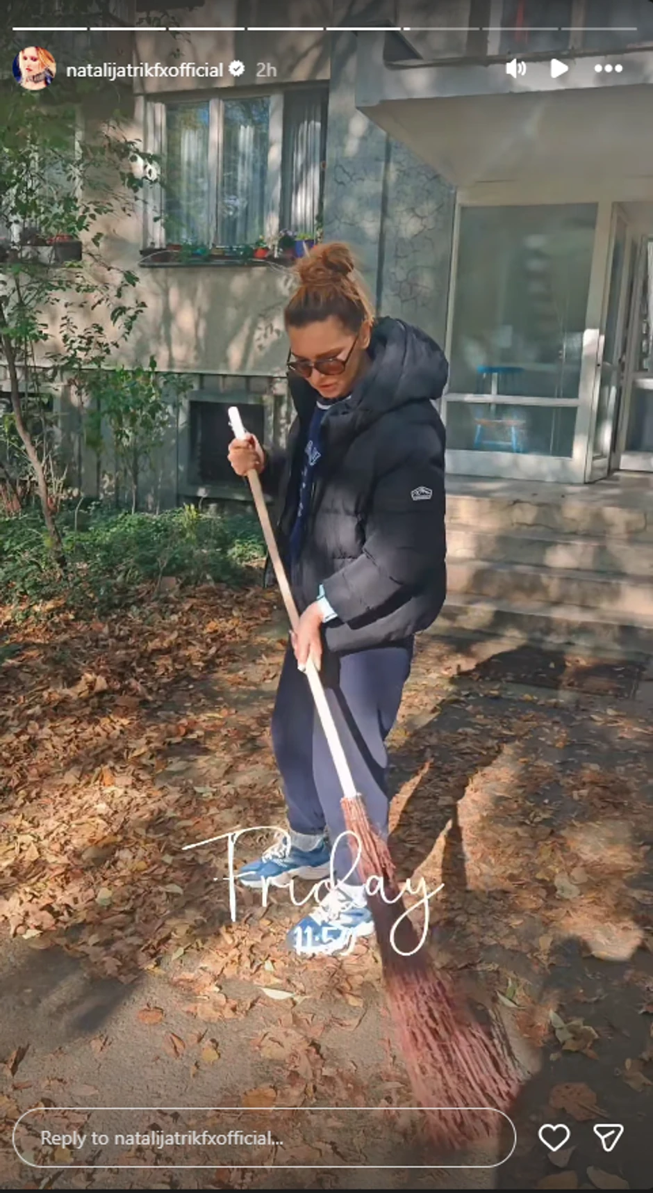 Natalija čisti lišće ispred zgrade