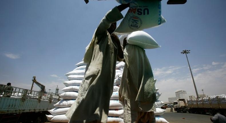 Dockers unload a US aid shipment at Port Sudan on the Red Sea coast, on May 5, 2016 