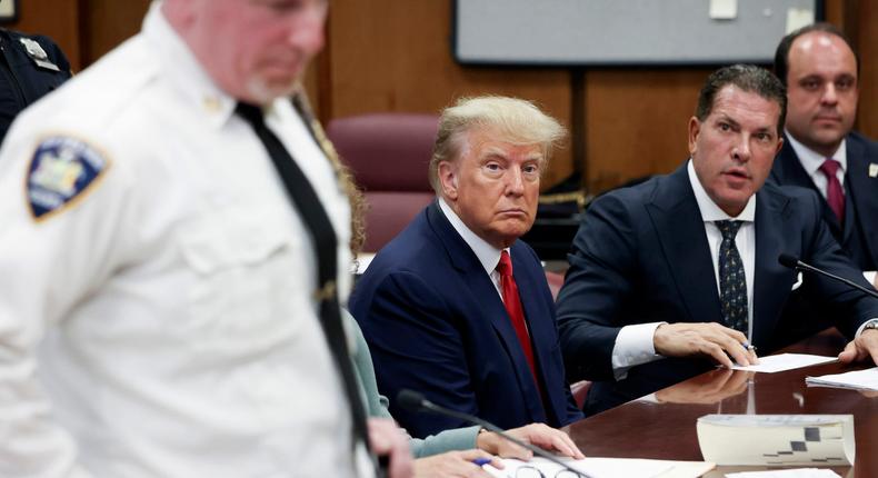Embattled former US President Donald Trump sits in the courtroom with his attorneys Joe Tacopina and Boris Epshteyn (R) during his arraignment at the Manhattan Criminal Court April 4, 2023 in New York City.Andrew Kelly-Pool/Getty Images