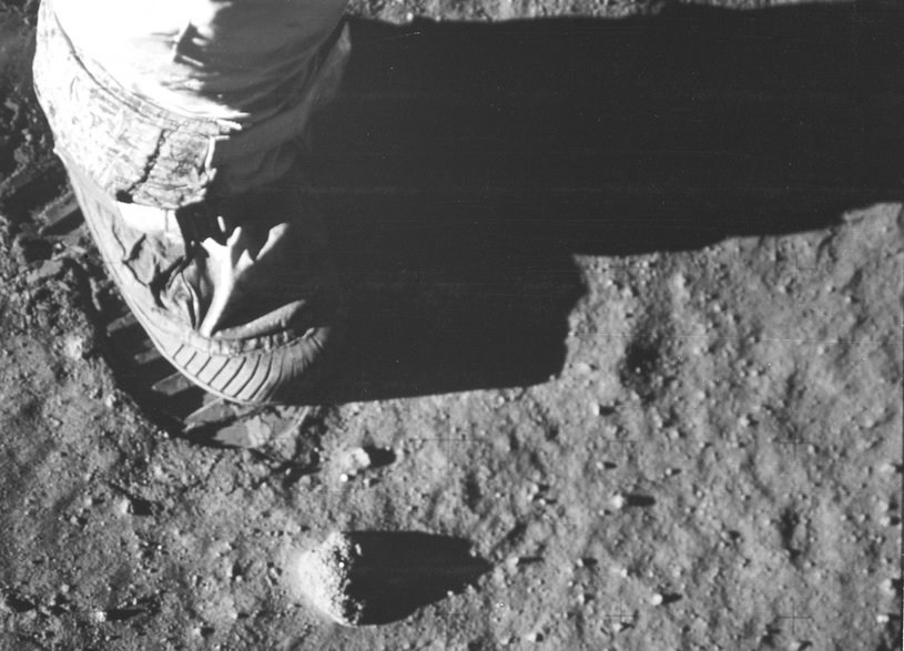 Zbliżenie stopy i odcisku stopy astronauty na księżycowej glebie podczas misji kosmicznej Apollo 11