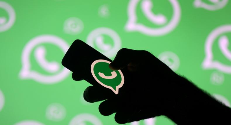 FILE PHOTO: A man poses with a smartphone in front of displayed Whatsapp logo in this illustration picture September 14, 2017. REUTERS/Dado Ruvic