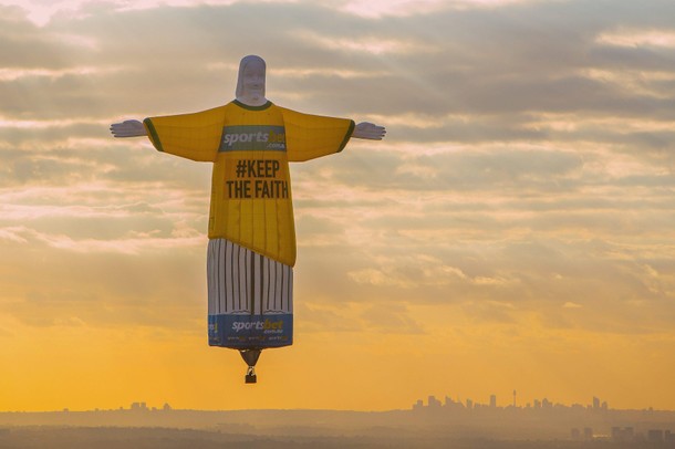 A balloon shaped in the famous 'Christ the Redeemer' statue floats at sunrise as part of an advertis