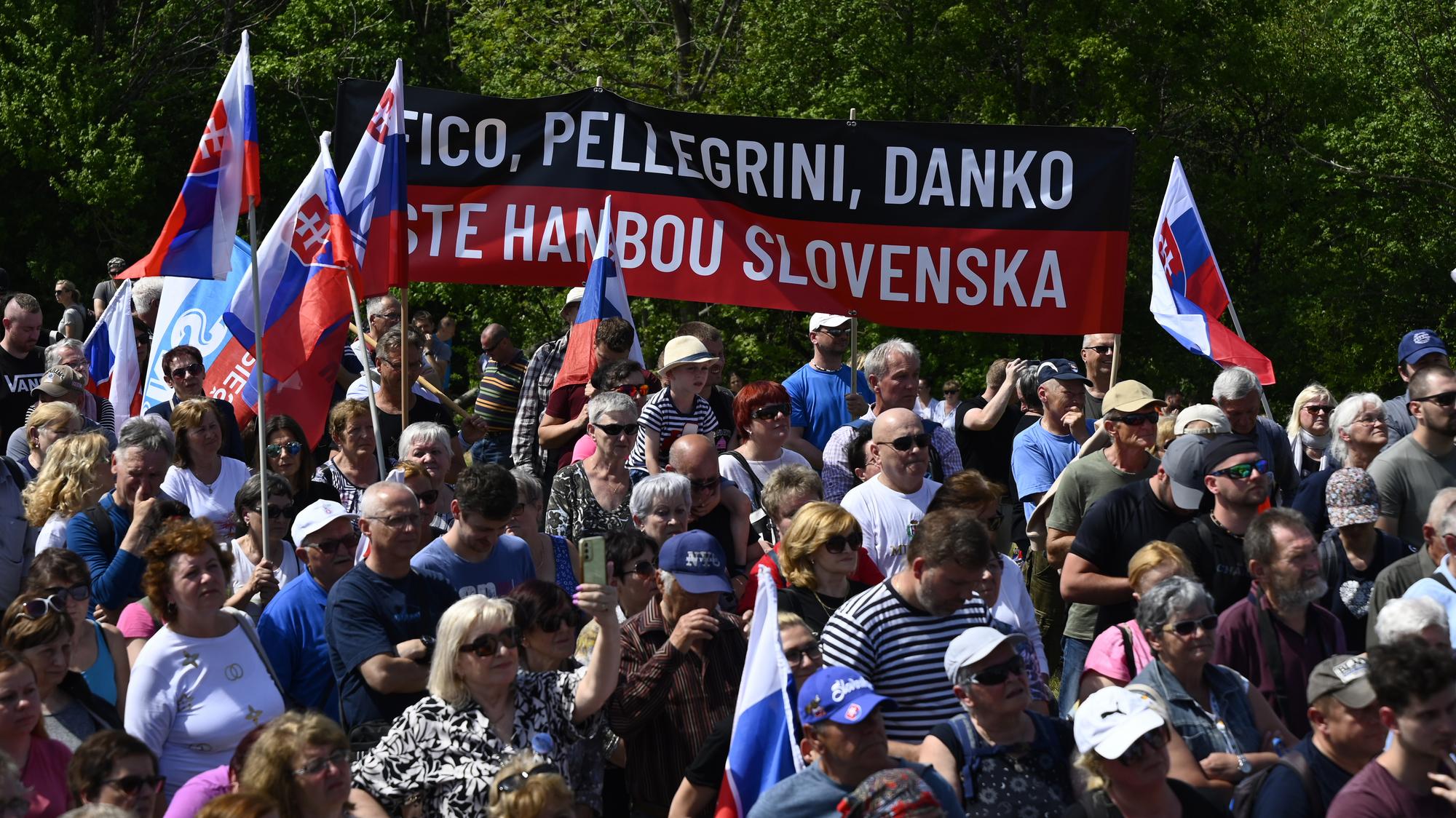 Ľudia držia slovenské vlajky a transparent na spomienkovom podujatí pri príležitostí 105. výročia tragickej smrti generála Milana Rastislava Štefánika.